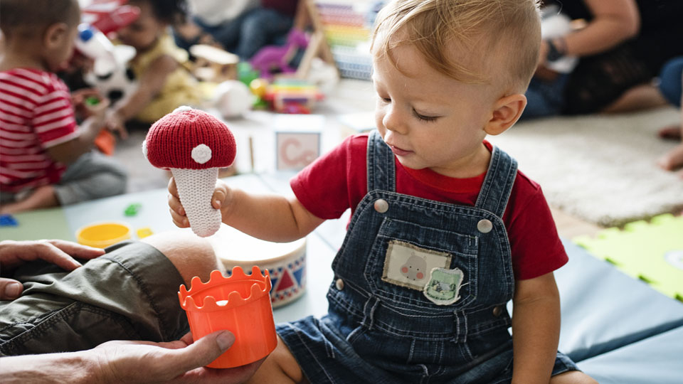 A young male toddler playing with toys in a children's toy room